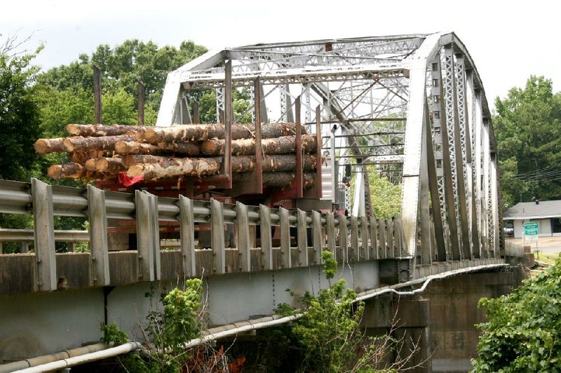 A logging truck crosses the aging Ouachita River Bridge on Arkansas 51 on its way to sawmills south of Arkadelphia. About 21 trucks a day make the crossing. 