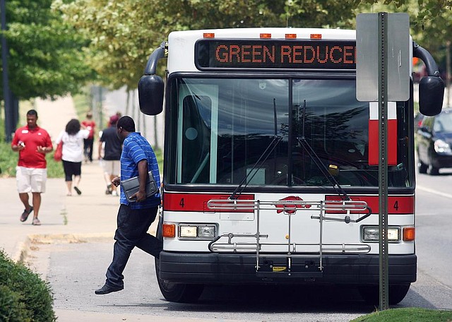 A student exits a Razorback Transit bus Monday near the University of Arkansas at Fayetteville’s Northwest Quad on Garland Avenue.