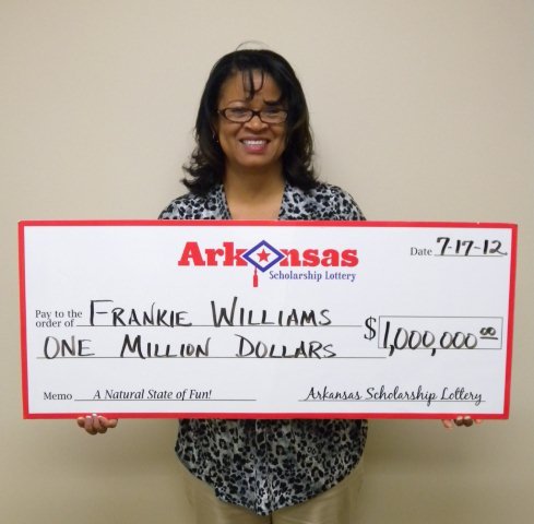 Frankie Williams poses with an oversized check after claiming a $1 million prize Tuesday.