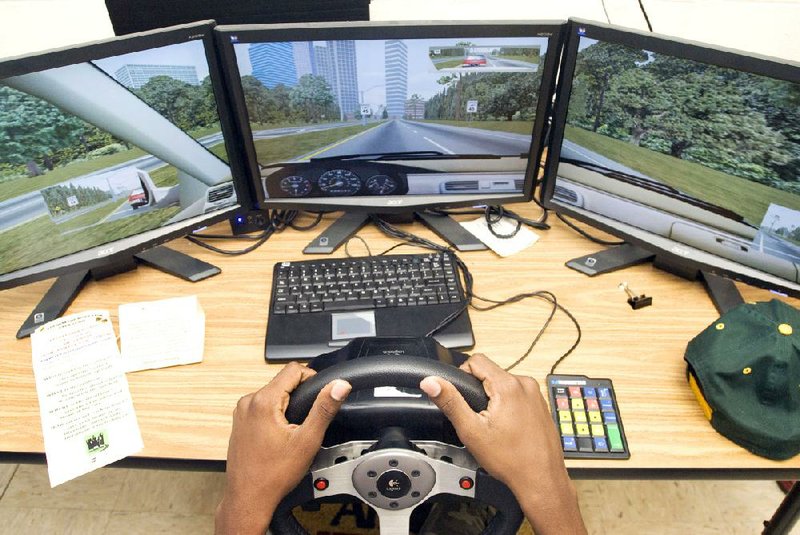Computer screens turn a tabletop into a simulated car in motion, giving a driver’s-eye view of the ever-changing highway. 