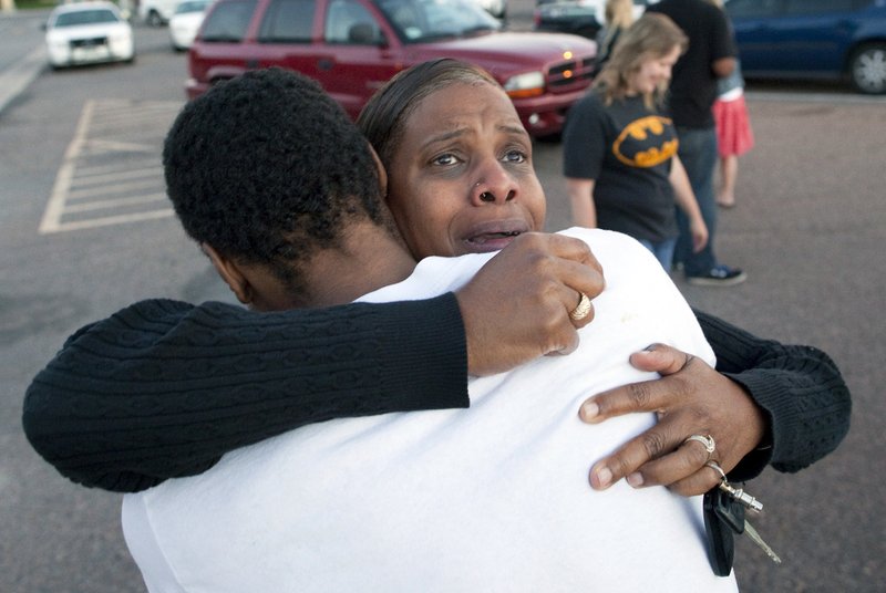 Shamecca Davis hugs her son Isaiah Bow, who was an eye witness to the shooting, outside Gateway High School where witnesses were brought for questioning Friday, July 20, 2012 in Denver. After leaving the theater Bow went back in to find his girlfriend. " I didn't want to leave her in there. But she's ok now," Bow said. A gunman wearing a gas mask set off an unknown gas and fired into a crowded movie theater at a midnight opening of the Batman movie "The Dark Knight Rises," killing at least 12 people and injuring at least 50 others, authorities said.