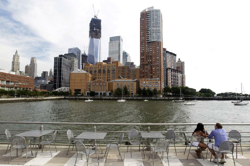 A couple enjoy the view of the skyline of lower west Manhattan from a snack bar at Hudson River Park. 