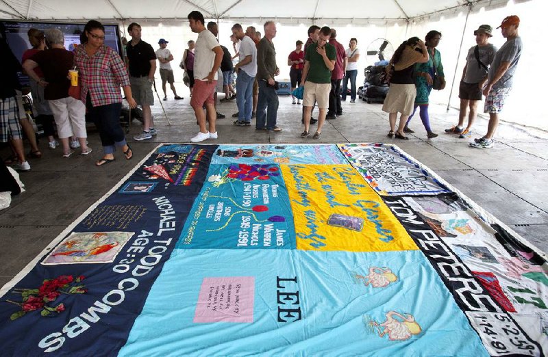 People gather Saturday around a section of the AIDS Memorial Quilt on the National Mall in Washington, D.C. Display of the entire quilt was delayed by rain. 