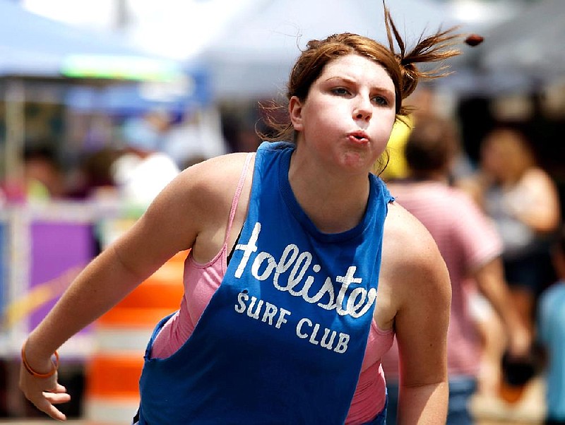 Tiffany Ward of Lamar competes in the peach-pit spitting contest Saturday during the 71st Johnson County Peach Festival in Clarksville. 
