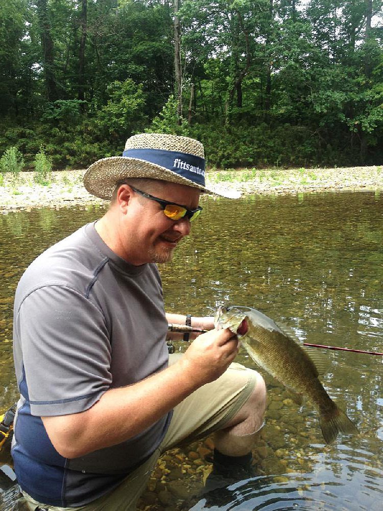 Alan Thomas of Russellville admires one of the many smallmouth bass he caught while wade fishing last Saturday on the Buffalo River at Steel Creek. 