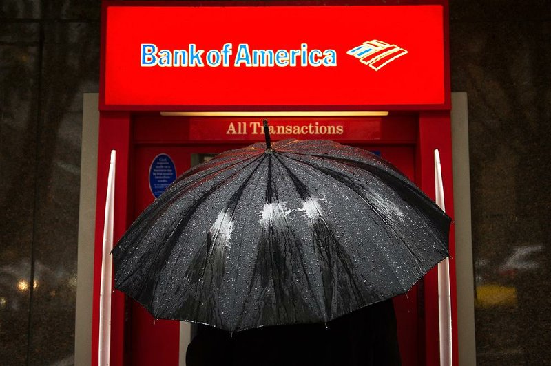 A pedestrian uses a Bank of America Corp. automated teller machine in San Francisco in March. The bank said it dropped 1,536 ATMs from its network in the first half of the year. 