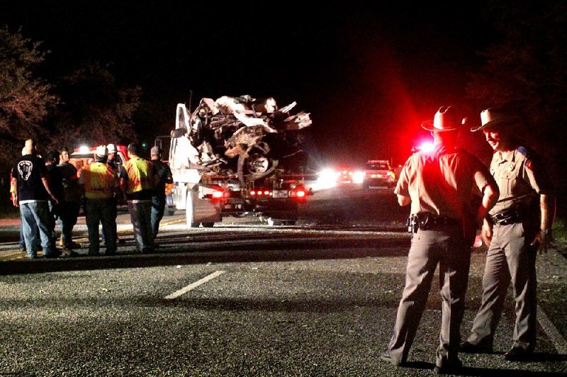 A pickup is hauled away from the scene of a fatal crash Sunday night near Goliad, Texas. 