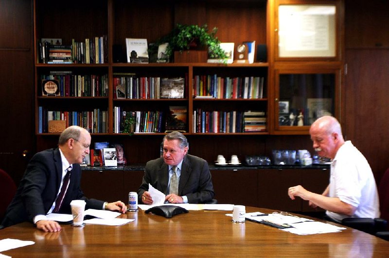 Don Pederson (from left), University of Arkansas vice chancellor for finance and administration, Chancellor G. David Gearhart and Associate Vice Chancellor for Facilities Management Mike Johnson talk with a board of trustees committee in a conference call Tuesday at the administration building on the Fayetteville campus.