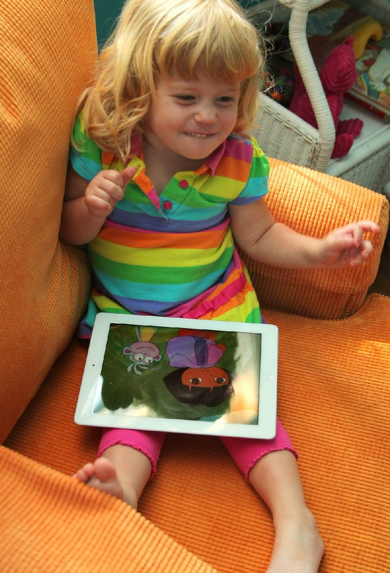 Lucy Kuykendall, 2, of Little Rock loves her iPad. New evidence suggests that young children learn more from interactive games than from watching video. 