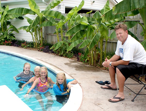 Tom Smith and four young swimmers enjoying the banana "tropical paradise" at the Smith home in Gravette. Swimmers, from the left, are Camille Smith, friends Hannah Frakes and Jessica Bookout and sister Cate Smith.