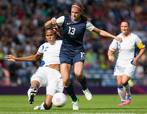 United States' Alex Morgan, center, is challenged by France's Wendie Renard, left, during their women's group G soccer match prior to the start of the London 2012 Summer Olympics, Wednesday, July 25, 2012, at Hampden Park Stadium in Glasgow. (AP Photo/Chris Clark)