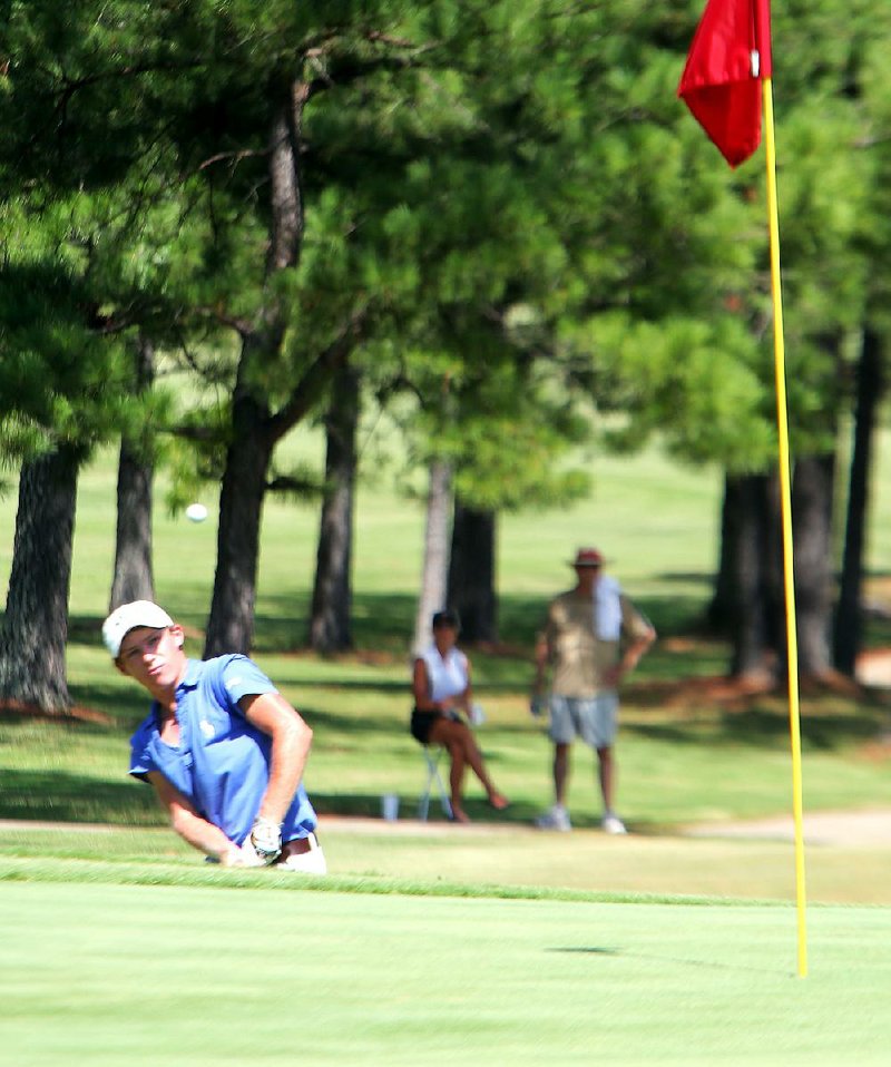 Tyler Green, of Benton, watches his ball after dhe chipped onto the green of the 11th hole in the finals for the ASGA Boys Junior Match Play golf at Eagle Hill Golf and Athletic Club in Little Rock Thursday.