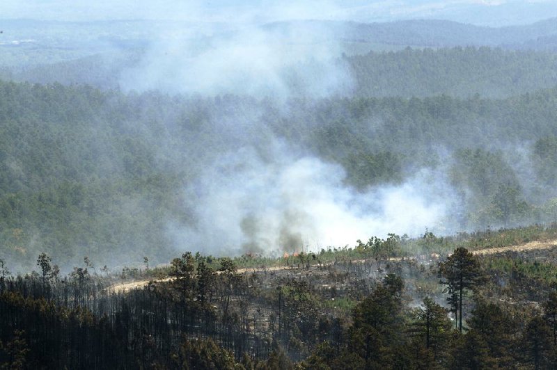 A wildfire continues to smolder near Ola on Thursday. Officials said the 1,400-acre blaze that prompted evacuations Wednesday has been fully contained. 