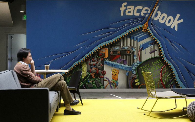 A Facebook Inc. employee relaxes in a lounge in May at headquarters in Menlo Park, Calif. Facebook reported a loss of $157 million Thursday in its first quarterly earnings report since becoming a public company. 