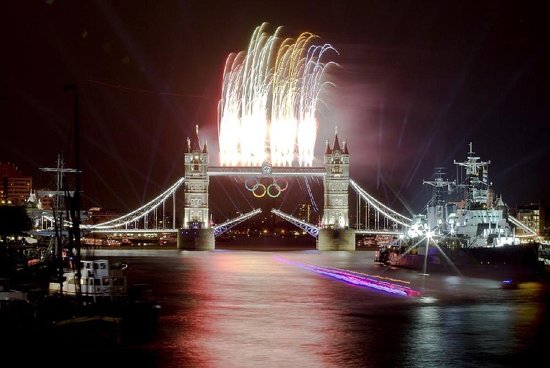 The Olympic cauldron is lit during the opening ceremony after the Olympic flame leaves a trail on the Thames River as fireworks explode above the Tower Bridge. 