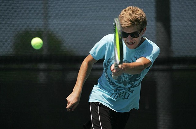 Arkansas Democrat-Gazette/RYAN MCGEENEY --07-27-2012-- Nick Holland of Bentonville, 18, returns a volley Friday afternoon while playing doubles tennis with friends at Bentonville's Memorial Park. Holland, who will be a senior at Bentonville High School this fall, wil be among thousands in the Bentonville School District returning to classes Aug. 20.
