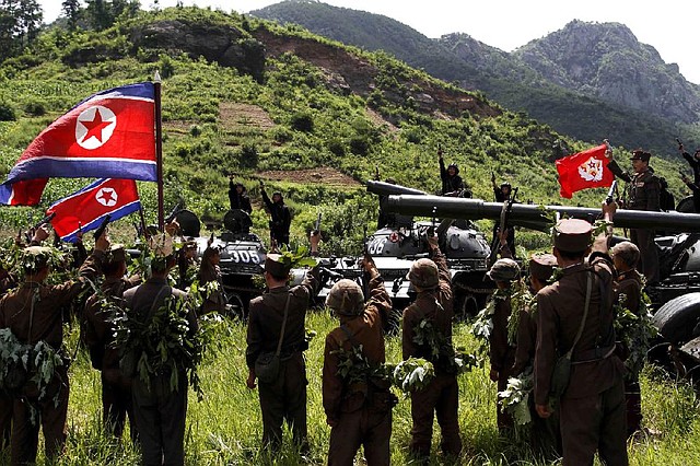 North Korean soldiers from the historic 105 tank unit denouncing joint U.S. and South Korean military exercises, raise slogans during a military exercise at an undisclosed location in North Korea Friday, July 27, 2012, marking the 59th anniversary of the armistice that ended the 1950-53 Korean War. The 105 tank unit is named after North Korean military officer Ryu Kyong Su, honored by North Korea for his role leading troops during the Korean War. (AP Photo/Jon Chol Jin)