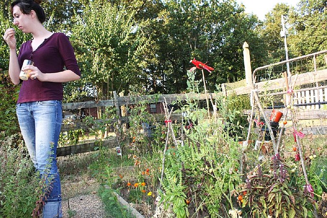 Patricia Graves, 22, sniffs lemon basil leaves in the garden of a home she housesat in June. 