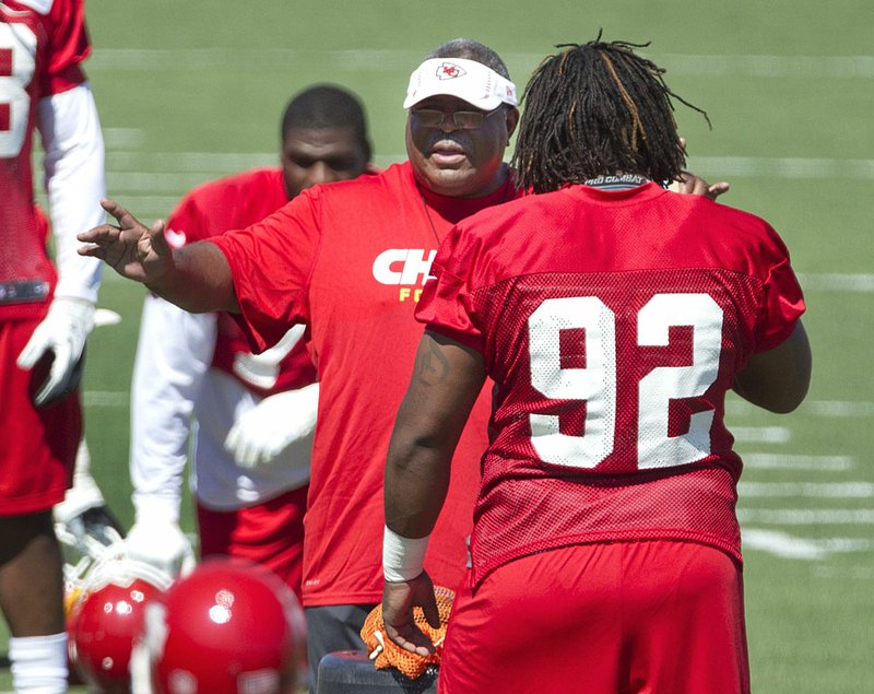 Kansas City Chiefs Coach Romeo Crennel talks with defensive tackle Dontari Poe (92) during the opening day of training camp in St. Joseph, Mo. The Chiefs are hoping to improve on last season’s poor showing, when they finished 7-9. 