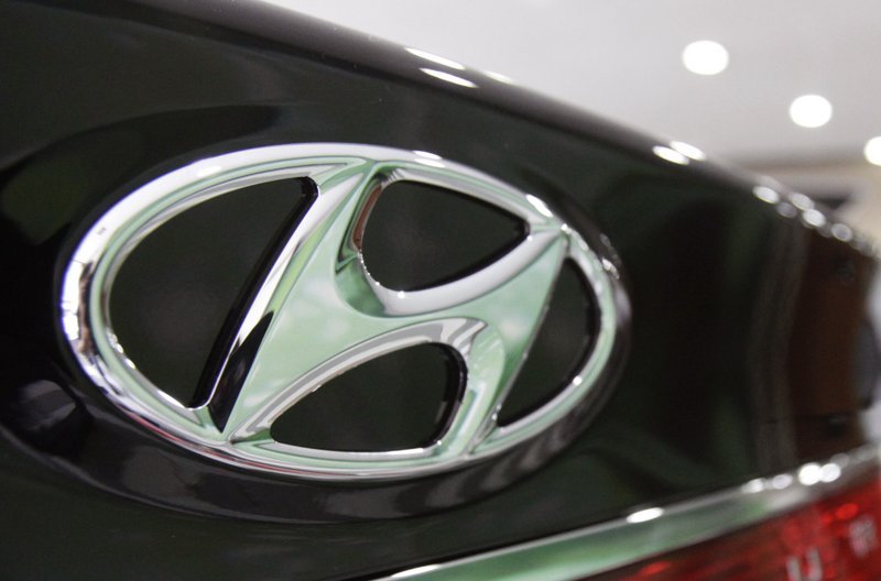 In this July 26, 2012 file photo, the logo of Hyundai Motor Co. is seen on its car at the company's showroom in Seoul, South Korea. Hyundai Motor Co. is recalling some Santa Fe SUVs and Sonata sedans because of problems with their air bags. The Santa Fe recall involves nearly 200,000 vehicles in the 2007 to 2009 model years. Hyundai dealers will reprogram the front passenger air bag sensors so they will accurately detect when a small adult is seated.
