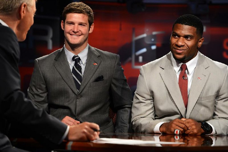 Arkansas quarterback Tyler Wilson (left) and running back Knile Davis talk with ESPN’s David Lloyd on the set of SportsCenter on Wednesday in Bristol, Conn. Both are considered candidates to win the Heisman Trophy heading into this season. 