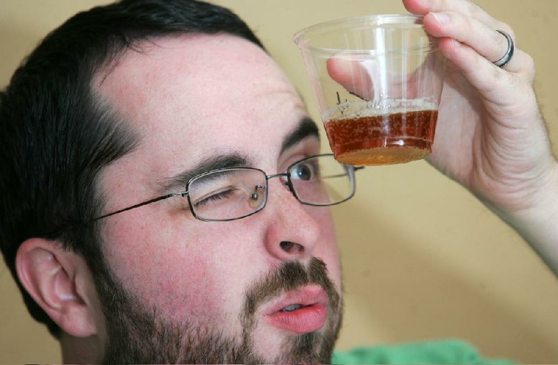 Jordan Embry of Pocola, Okla., assesses the color and clarity of a beer entered in Saturday’s All-American Brew Off. 