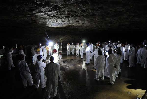 Ron Redman, center left, talks to a group of more than 50 volunteers July 28, 2012, about the layout of the dance floor area inside the Wonderland Cave during a cleanup day at the historic cave in Bella Vista.