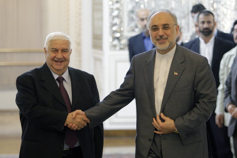 Iranian Foreign Minister Ali Akbar Salehi, right, shakes hands with his Syrian counterpart Walid al-Moallem, prior to their joint press conference, in Tehran, Iran, Sunday, July 29, 2012.