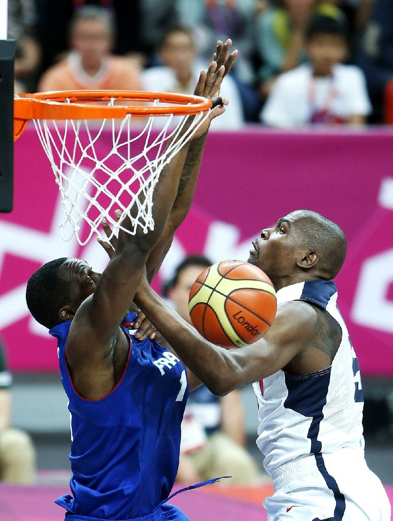 American forward Kevin Durant (right) tries to score past French defender Florent Pietrus during the first half of Sunday’s game at the Summer Olympics in London. Durant led the U.S. team with 22 points in a 98-71 victory over France. Kevin Love added 14 points and LeBron James had eight assists. 