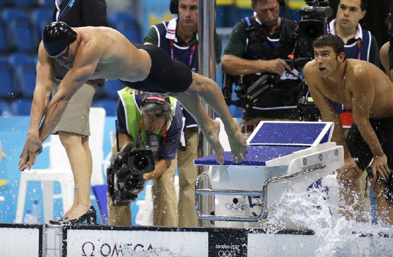 Ryan Lochte dives into the pool for the final leg of the men’s 400-meter freestyle relay while teammate Michael Phelps looks on. The United States finished second to France in the event despite having a half-body-length lead when Lochte dove in. 