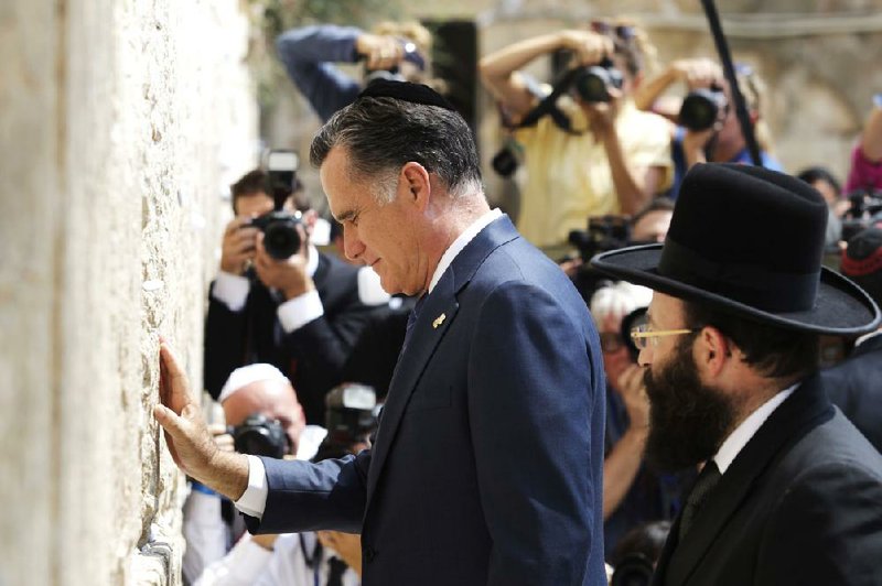Republican presidential candidate and former Massachusetts Gov. Mitt Romney pauses at the Western Wall in Jerusalem on Sunday. Romney will depart Israel today for Poland for a meeting with the Polish premier and with former President Lech Walesa. Video is available at arkansasonline.com/videos. 