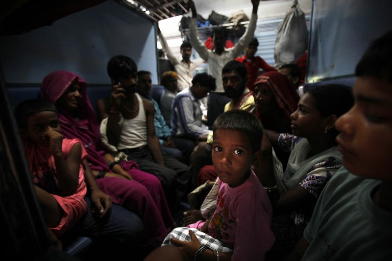 Passengers sit in a train Monday, July 30, 2012, waiting for power to get restored at a railway station in New Delhi, India.