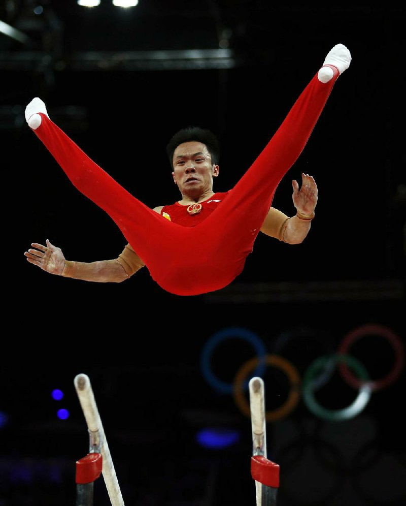 Chinese gymnast Guo Weiyang performs on the parallel bars Monday during the men’s team competition in the London Olympics. China won the gold medal with a score of 275.997 points. 