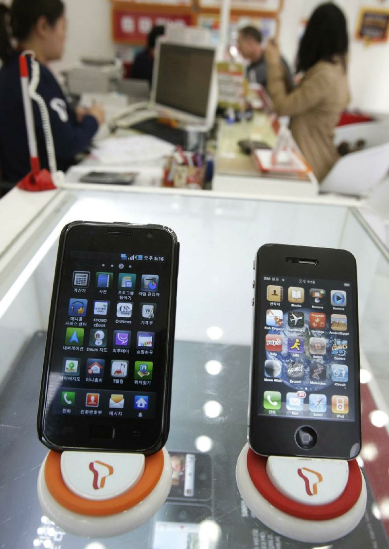 Samsung Electronic’s Galaxy S (left) and Apple’s iPhone 4 are displayed at a mobile-phone shop in Seoul, South Korea, in April. Jury selection began Monday in Apple Inc.’s lawsuit against Samsung Electronics Co. 