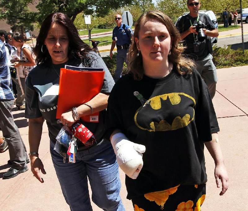 An injured woman wearing a Batman shirt departs the Arapahoe County Courthouse on Monday after an arraignment hearing for theater-massacre suspect James Holmes in Centennial, Colo. 