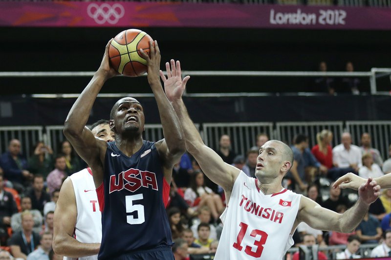 USA's Kevin Durant, left, drives to the basket against Tunisia's Amine Rzig during a men's basketball game at the 2012 Summer Olympics, Tuesday, July 31, 2012, in London.