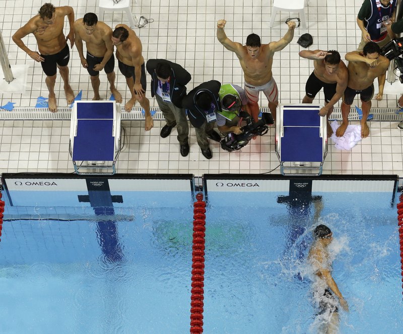 United States' Conor Dwyer, fourth from right, United States' Ryan Lochte, third from right, United States' Ricky Berens, second from right, and United States' Michael Phelps, in the water, react as they win gold in the men's 4x200-meter freestyle relay swimming final at the Aquatics Centre in the Olympic Park during the 2012 Summer Olympics in London, Tuesday. With the win, Phelps collected his 19th Olympic medal, most all-time.