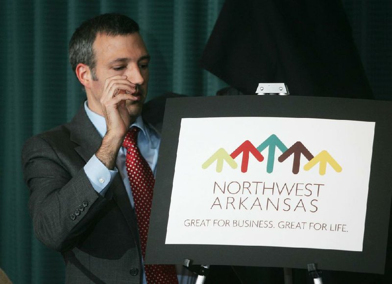 Mike Harvey, chief operating officer of the Northwest Arkansas Council, unveils a new logo and slogan for regional economic development Tuesday in Springdale.