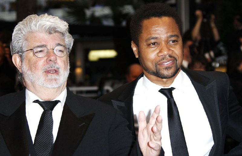 Director George Lucas, left, and actor Cuba Gooding Jr arrive for the screening of Cosmopolis at the 65th international film festival, in Cannes, southern France, Friday, May 25, 2012. On Tuesday, Disney announced that it purchased LucasFilm for $4.05 billion. (AP Photo/Joel Ryan)