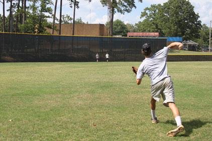 After stretching and warm-up, Connor Gilmore throws progressively longer tosses to Robert Staten (left) and Kevin Sheredy at Lamar Porter Field in Little Rock. A graduate of Catholic High School, Gilmore will attend the University of Central Arkansas in Conway. 