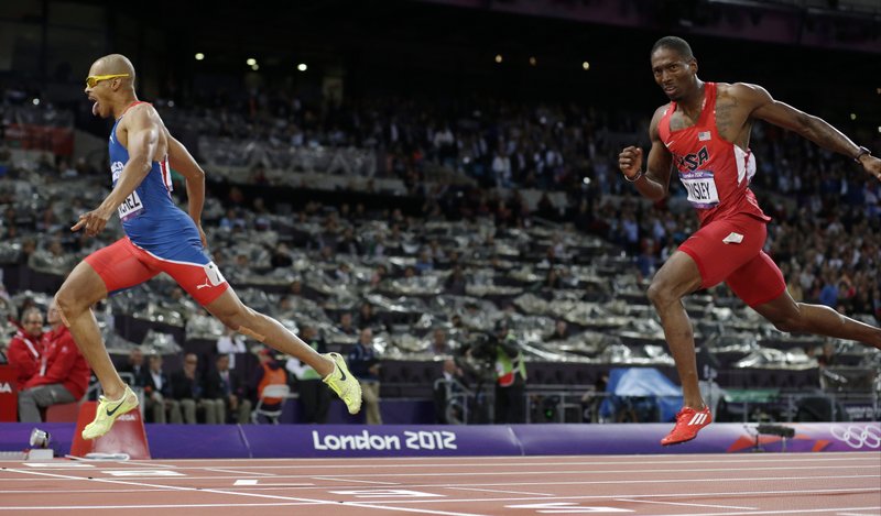 Dominican Republic's Felix Sanchez, left, crosses the finish line to win ahead of United States' Michael Tinsley in the men's 400-meter hurdles final during the athletics in the Olympic Stadium at the 2012 Summer Olympics, London, Monday,