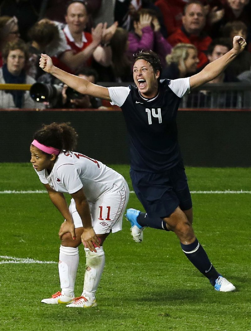 U.S. forward Abby Wambach (14) celebrates the American’s 4-3 semifinal victory Monday next to dejected Canadian Desiree Scott. Alex Morgan scored the winning goal in the final minute of extra time. 