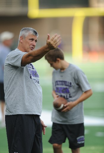 Fayetteville assistant coach Joe Thoma works Thursday, Aug. 2, 2012, with sophomore kicker James McMahan during practice at Harmon Field.