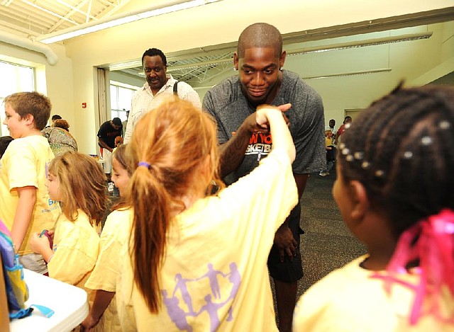 New York Knicks guard Ronnie Brewer (Fayetteville, Arkansas Razorbacks) greets students Thursday as they line up to receive school supplies at the Fayetteville Boys and Girls Club. Current members of the Arkansas men’s and women’s basketball teams also were on hand to distribute school supplies to students. Video available at arkansasonline.com/videos. 