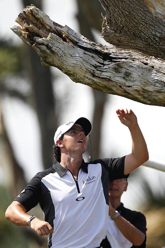 Rory McIlroy reaches for his ball after it became stuck in a tree on the third hole during Saturday’s round at the PGA Championship. McIlroy took a drop and a penalty but made par on the hole. 