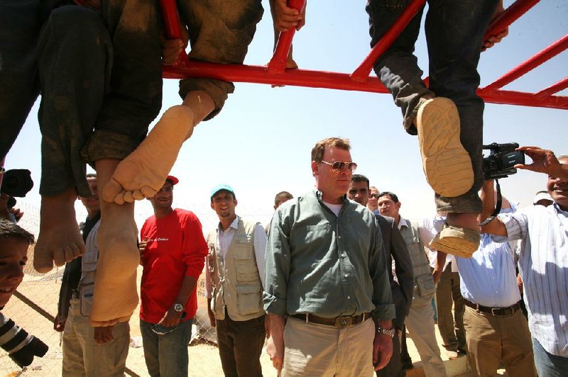 Canadian Foreign Minister John Baird talks with Syrian refugees Saturday at a camp in Mafraq, Jordan, where he pledged $6.5 million more in aid for Jordan’s efforts to help displaced Syrians. 