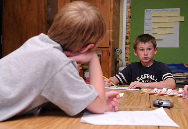 Lucas Burchar, 9, left, listens as Cameron Green, 9, explains to classmates how he solved a fraction problem May 7 in Leticia Greene’s class at West Fork Elementary. New Common Core State Standards, which will be implemented in all elementary classrooms in the coming school year, will introduce more complex math problems to students at a younger age. 