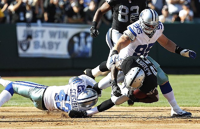 Dallas defensive back Gerald Sensabaugh (left) and defensive lineman Sean Lissemore tackle Oakland Raiders running back Darren McFadden (Pulaski Oak Grove, Arkansas Razorbacks) on Monday during the Cowboys’ 3-0 exhibition victory. 