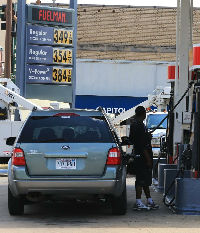 A motorist pumps gas Monday afternoon at the Shell station at West Eighth Street and Broadway in downtown Little Rock. 