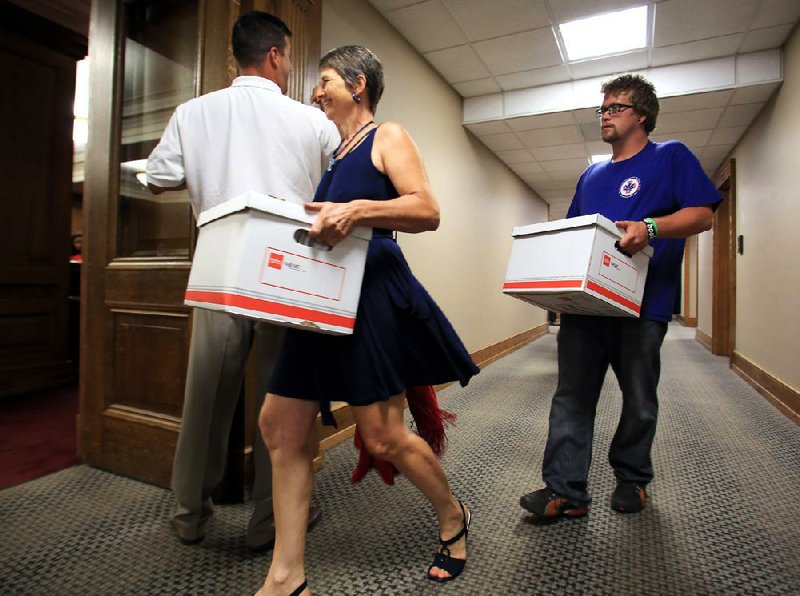 Emily Williams and Brian Hill help deliver boxes of signatures to the secretary of state’s office Monday, Aug. 13. Arkansans for Compassionate Care collected 74,406 signatures to try to ensure the 2012 Arkansas Medical Marijuana Act is on the November ballot. 